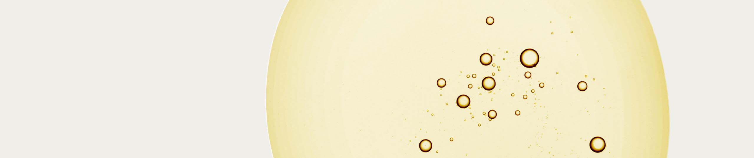 Close-up of champagne bubbles in a cream-colored background.